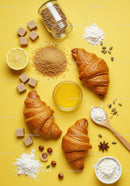 Fresh croissants with ingredients on bright yellow background