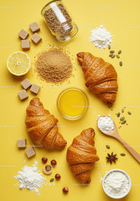 Fresh croissants with ingredients on bright yellow background