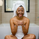 Young Woman with Clay Face Mask Relaxing in Bathroom Spa