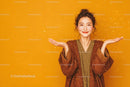 Happy Woman in Brown Jacket with Bright Smile Against Yellow Background