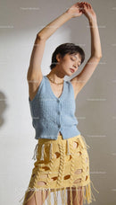 Young woman in knitted blue top and yellow skirt