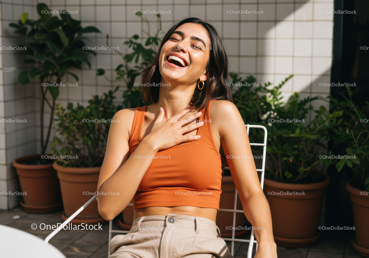 Happy Young Woman Laughing Outdoors on Stylish Chair with Garden Background