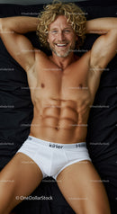 Relaxed smiling man lying on bed in white underwear