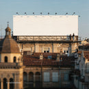 Two people talking near large blank rooftop billboard
