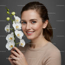 Portrait of a Cheerful Woman with White Orchid Flower on Gray Background