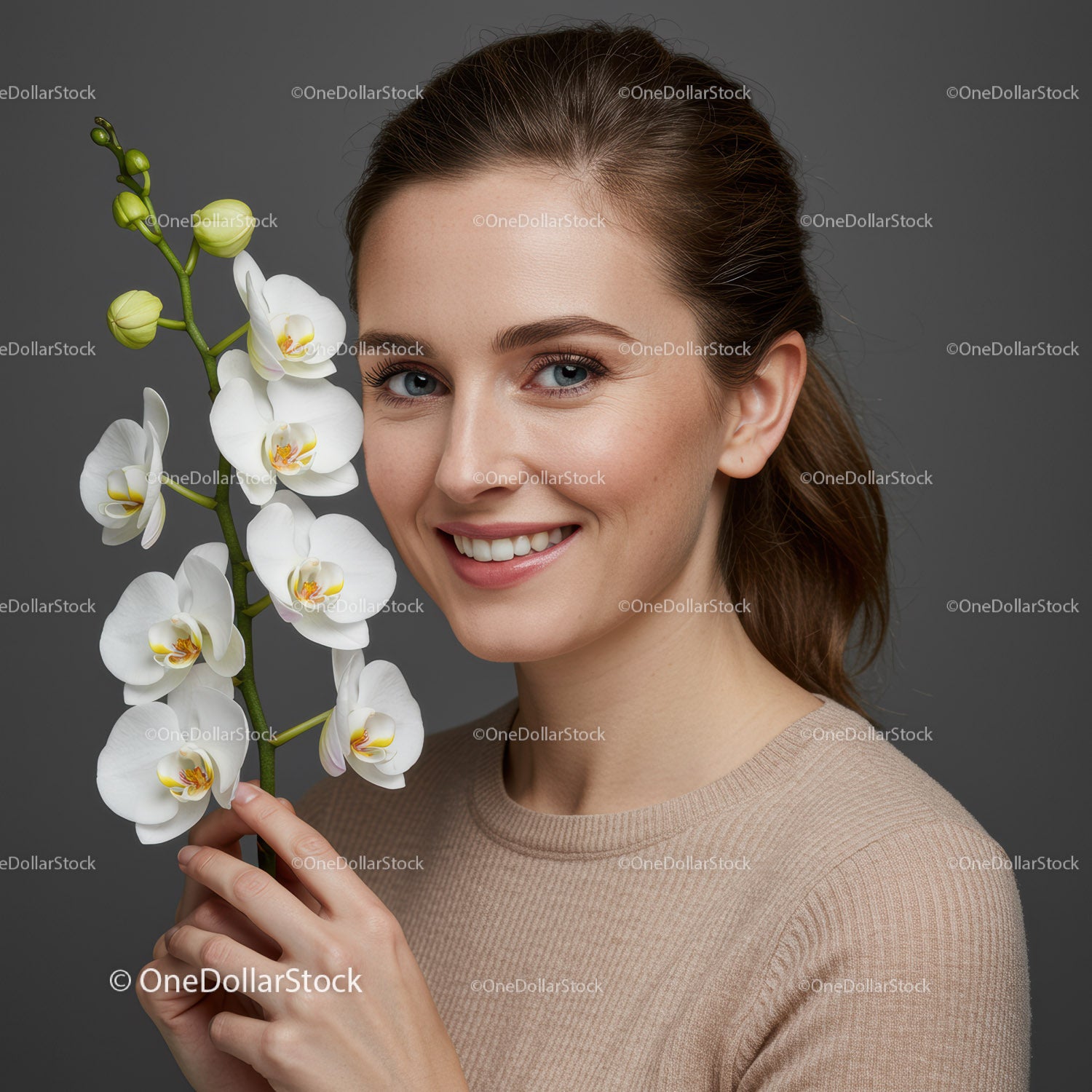 Portret wesołej kobiety z białym kwiatem orchidei na szarym tle