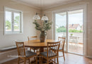 Cozy dining area with round wooden table and balcony view