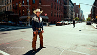 Man in Traditional Cowboy Outfit Standing on City Street