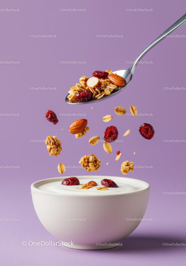 Healthy granola and nuts falling into yogurt bowl