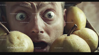 Surprised Man with Wide Eyes Among Green Pears in Close-Up