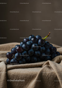 Fresh dark grapes resting on soft beige fabric