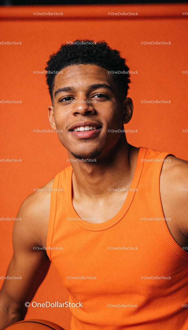 Young athlete in orange tank top holding basketball