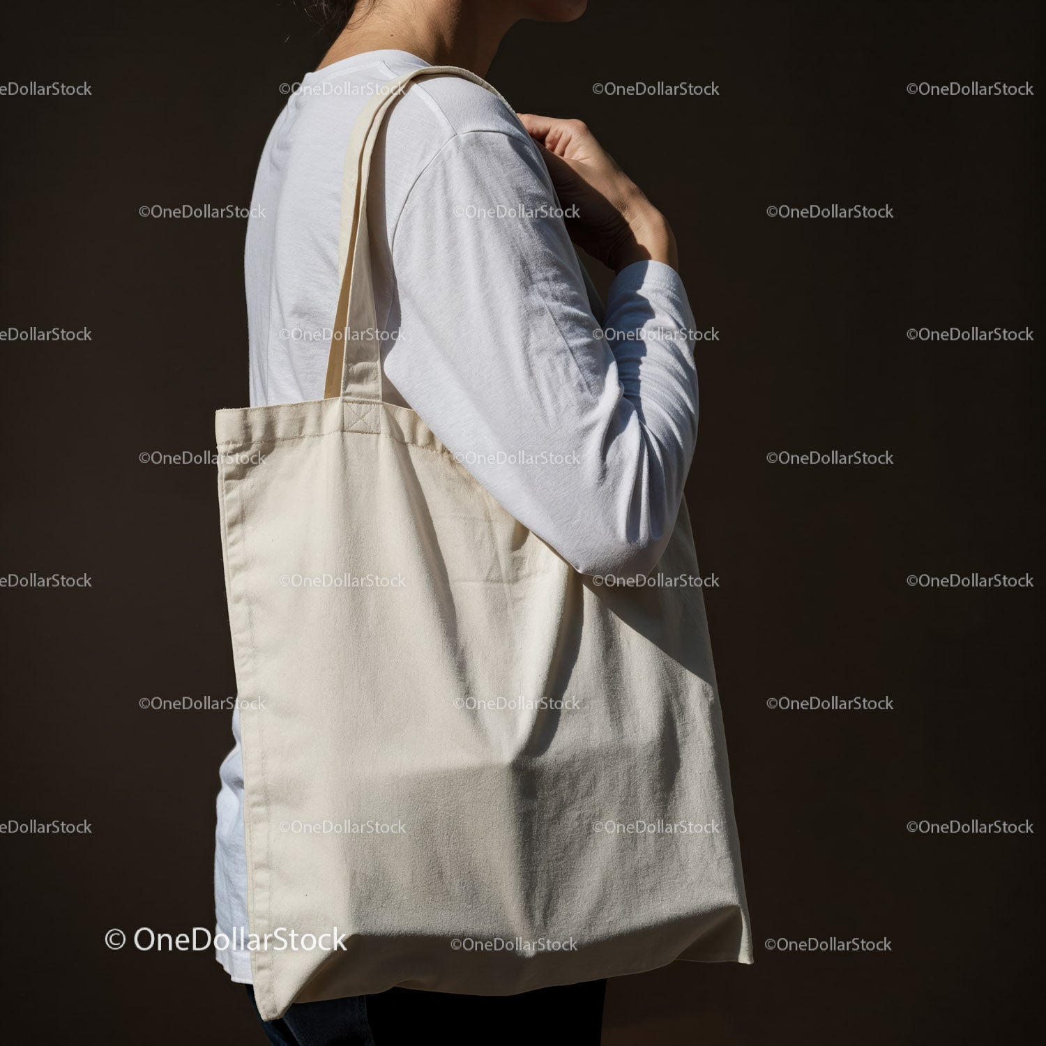 Person carrying blank canvas tote bag on shoulder