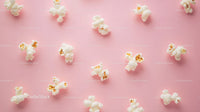 Popcorn scattered on pink background with fresh crunchy snack imagery