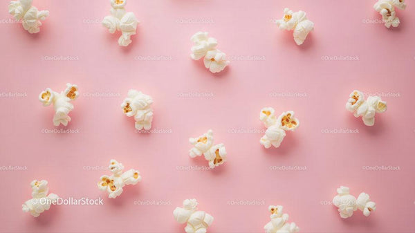 Popcorn scattered on pink background with fresh crunchy snack imagery