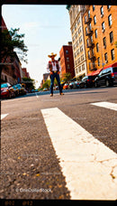 Man in cowboy attire standing on city street crosswalk