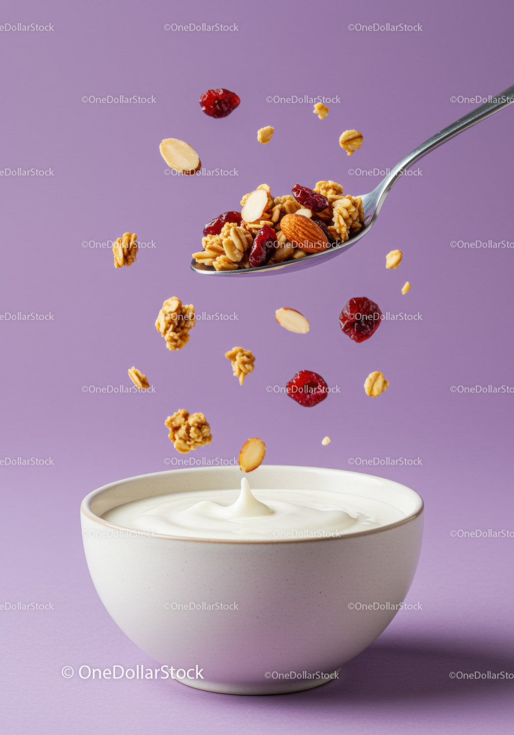 Nutty granola and dried fruit falling into yogurt bowl