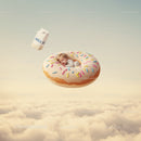 Sleeping baby nestled inside giant sprinkled donut above clouds