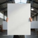 Person holding blank white poster in industrial space