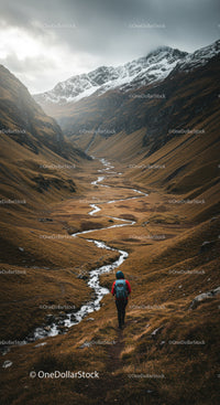 Hiker Walking Through Scenic Mountain Valley with Stream and Snow-Capped Peaks