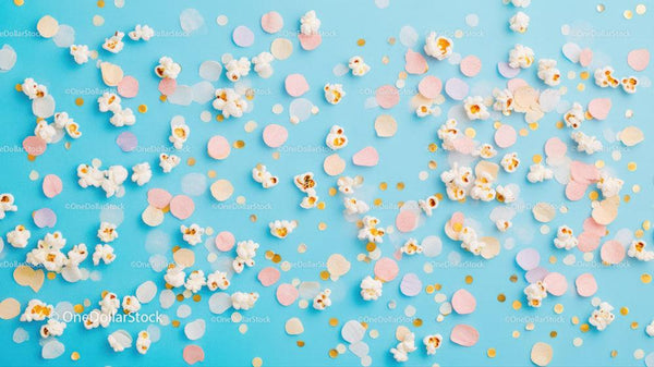 Colorful Popcorn and Confetti Scatter on Light Blue Background for Celebrations