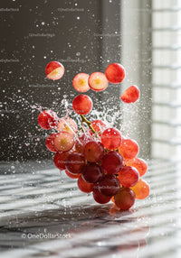 Fresh red grapes splashing in water droplets