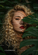 Glamorous Woman with Curly Blonde Hair Among Tropical Leaves