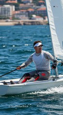 Man Sailing a Small Yacht in Blue Ocean Water