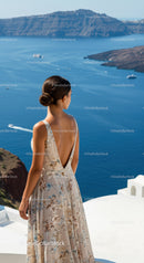 Woman in floral dress overlooking blue coastal cliffs