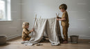 Two children building a cozy indoor play tent at home