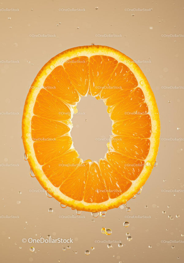 Fresh orange slice with water droplets on beige background