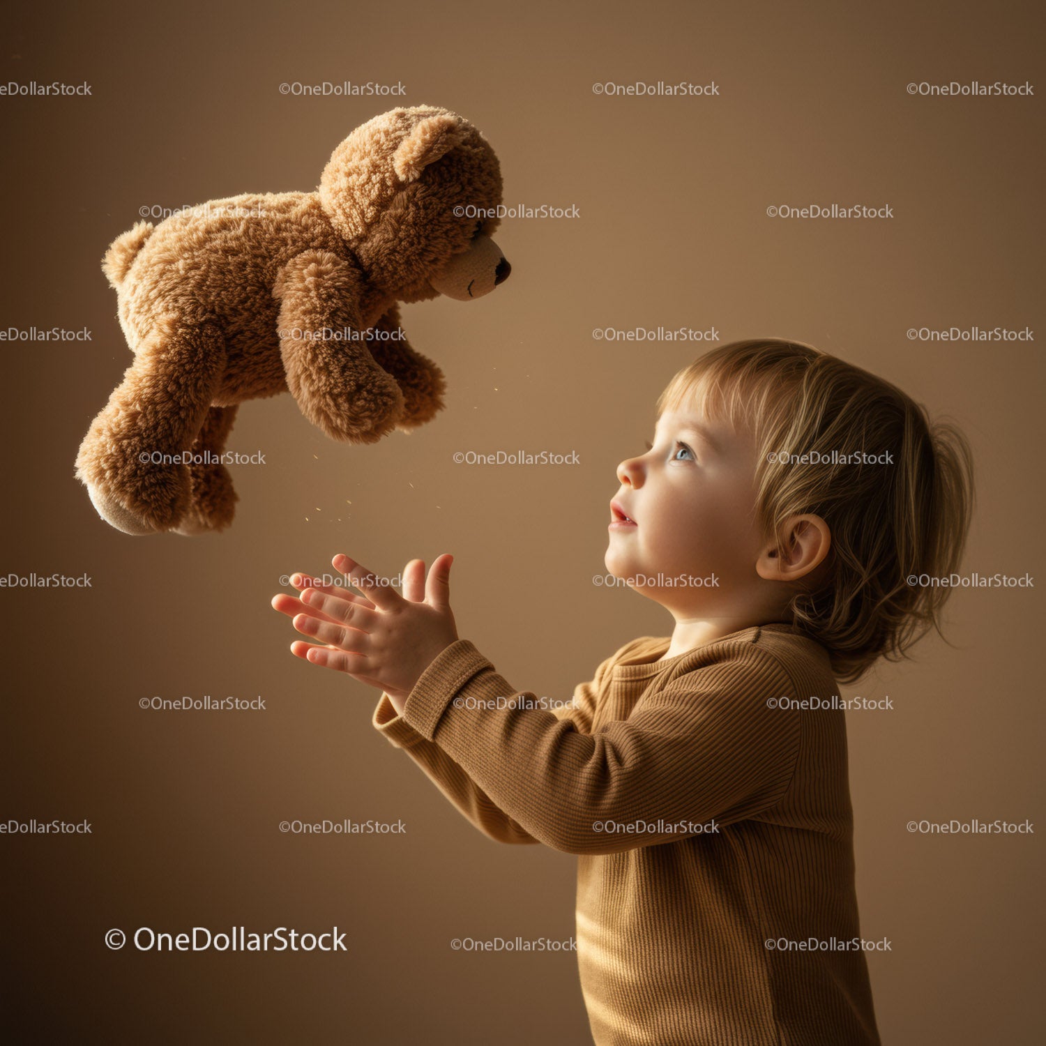 Toddler reaching for teddy bear in warm light