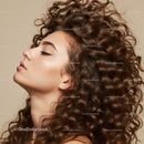Profile of young woman with long curly hair and closed eyes