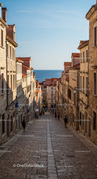 Charming Coastal Town Street with Historic Mediterranean Buildings and Sea View