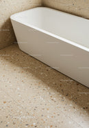 Elegant White Freestanding Bathtub on Beige Terrazzo Floor