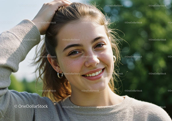 Young Woman Smiling Outdoors in Natural Light with Green Background