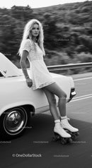 Young woman roller skating beside vintage car on road