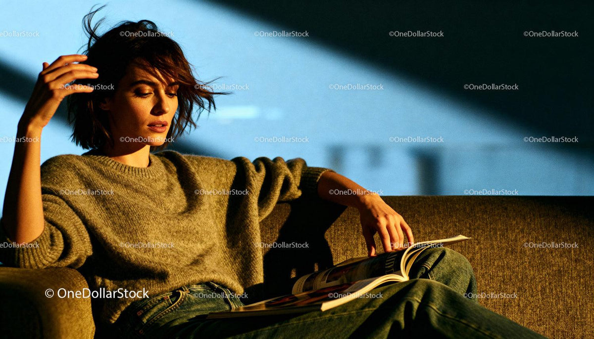 Woman Relaxing on Sofa Reading a Magazine in Cozy Light