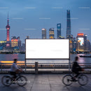 City skyline with illuminated billboard and cyclists at dusk