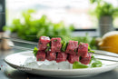 Fresh Raw Beef Cubes on Skewers with Basil Over Ice