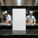 Blank menu card on counter in busy professional kitchen