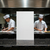 Blank menu card on counter in busy professional kitchen
