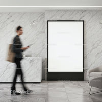 Blurred woman walking past blank advertising poster indoors