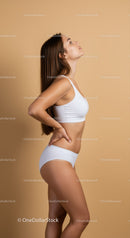 Elegant Young Woman in White Sportswear in Profile Pose with Beige Background