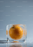 Fresh orange frozen inside clear ice cube