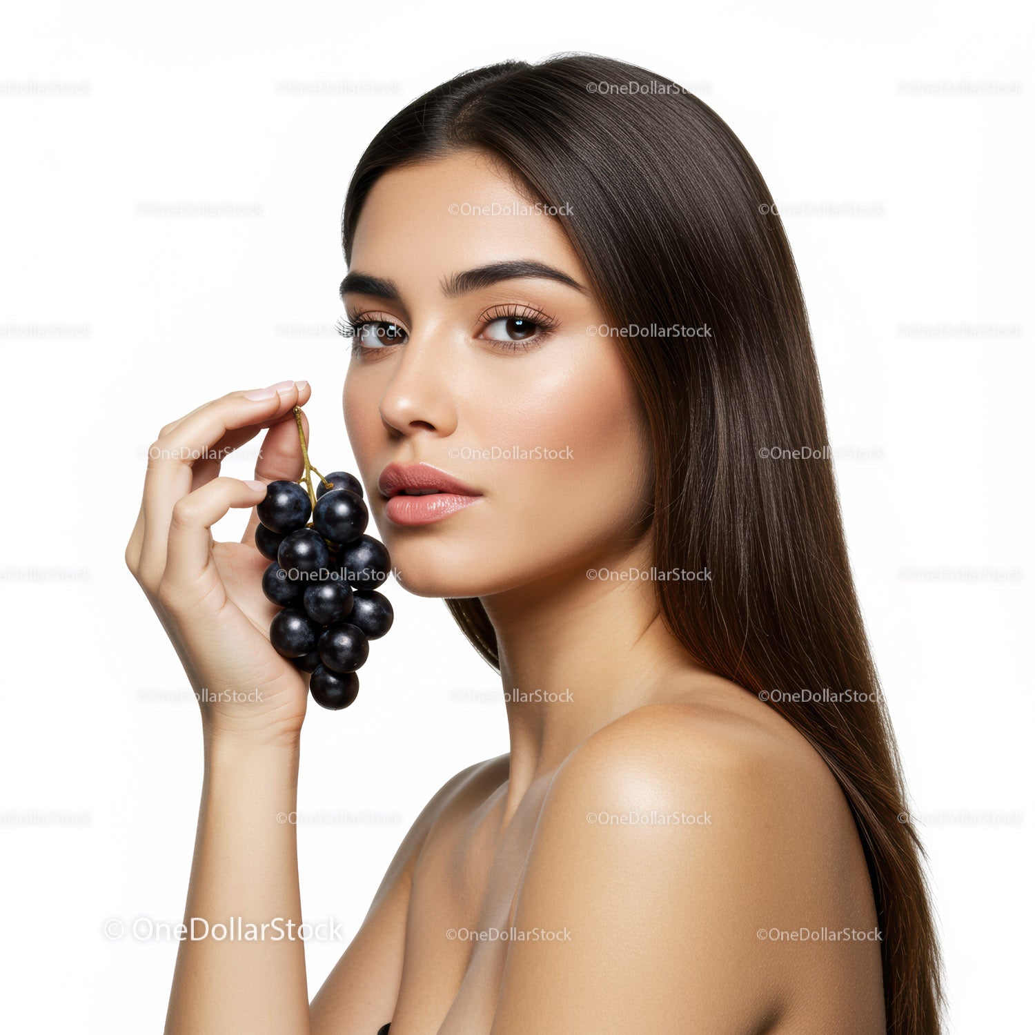 Elegant Woman with Long Hair Holding Bunch of Black Grapes in Studio