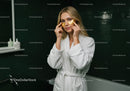 Young Woman Applying Gold Under Eye Patches in Spa Bathroom