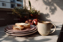 Cozy Breakfast Table with Mug Bread and Pomegranate in Natural Light