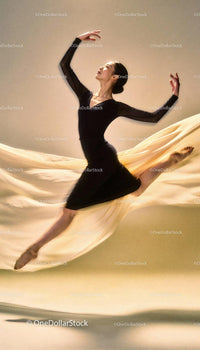 Graceful ballet dancer leaping with flowing fabric