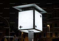 Illuminated directional signpost glowing at night